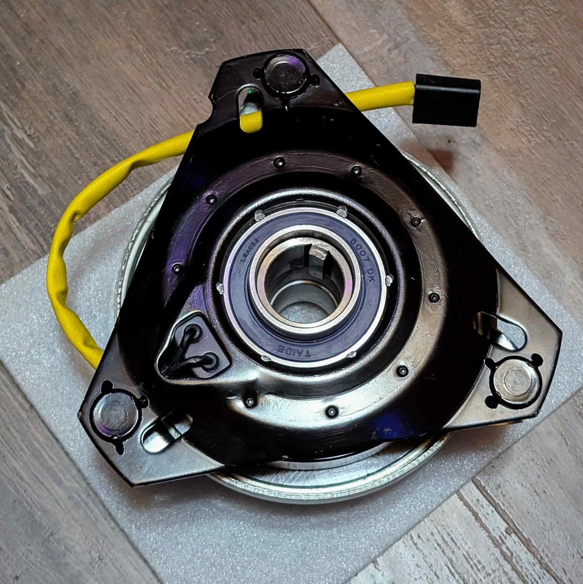 Flip side of replacement PTO clutch for John Deere AM119536 showing mounting plate and 1-1/8 inch keyed bore