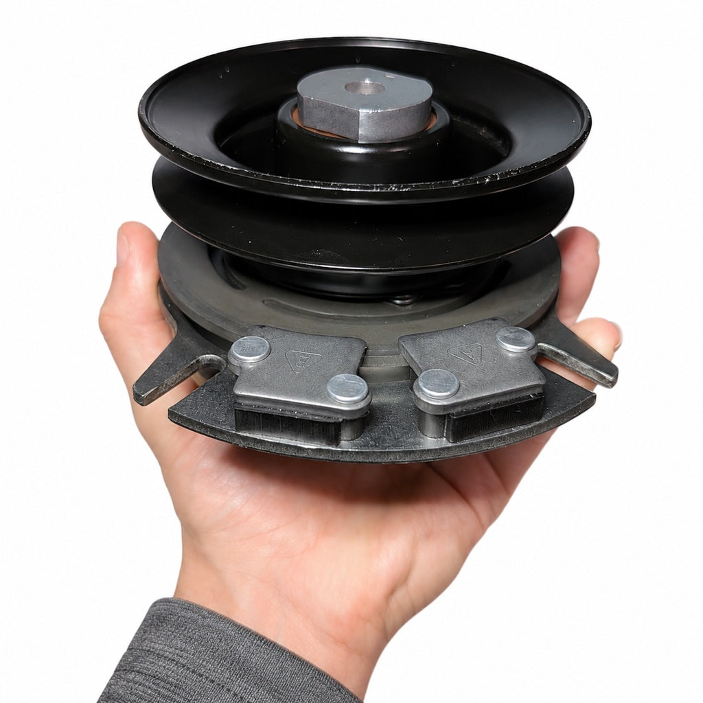 Hand holding a John Deer PTO clutch shown against white background.